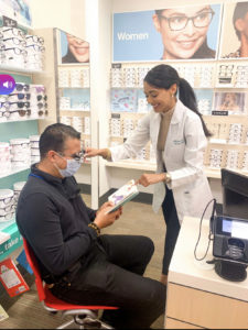 photo of Dr. Joseph in a Walmart optical where she helps a patient and gives back tot he community