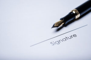 A pen above an empty signature line - is your last name the same as your diploma