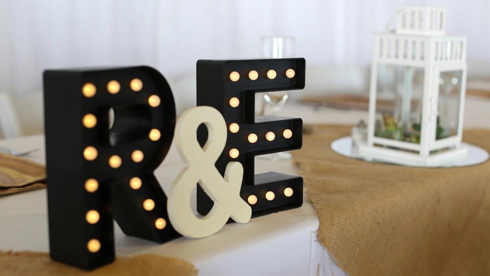 A photo of two light-up letters R and E, at a wedding reception