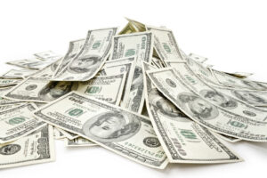 Pile ofdollar bills on white background representing profit sharing