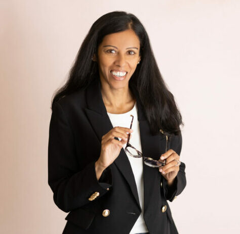 portrait of Dr. Ramanathan holding a pair of eyeglasses as she talks about her career choices. 