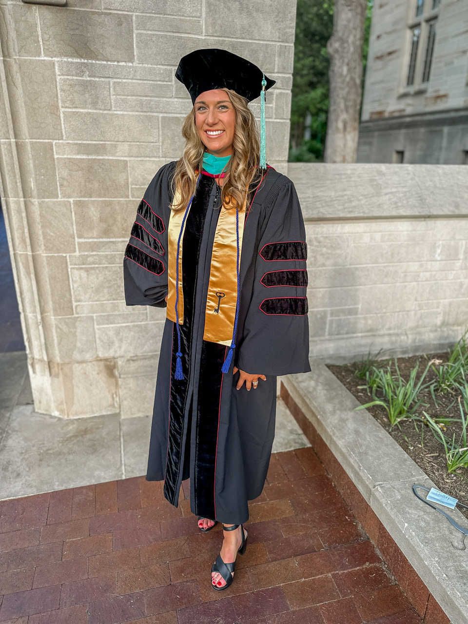 Dr. Kaitlyn Duran in graduation regalia - she talks about how her organizational skills and time management focus to prioritize the things that were most important to her. 