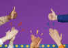 Women in the News- August 2023 group of hands with thumbs up and hands clapping against purple background