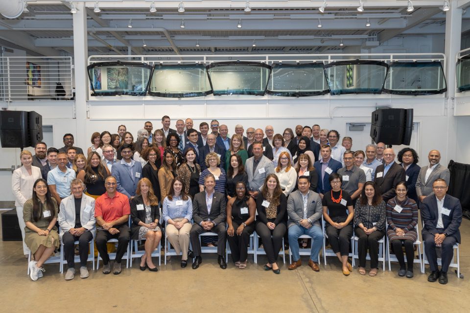 photo of about 60 people lined up in 5 rows of chairs and standing - attendees of the industry collaborative