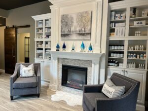 Crystal Brimer's reception area of the dry eye equation with a fireplace flanked by bookshelves and two gray wing chairs