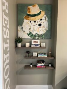 restroom with large signage and painting of a dog with glasses and straw hat