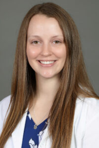 Dr. Ashleigh Sprouse in white coat talking about myopia management