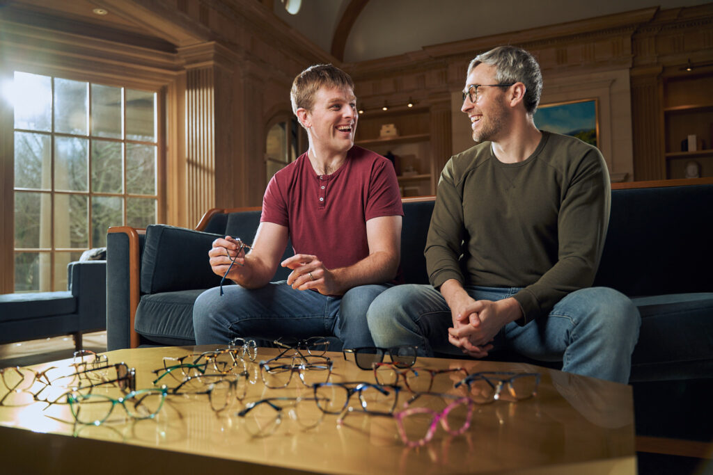 Launching 2BB brand: brad and bryan manning , two blind brothers, sitting on a couch with about 15 2BB brand frames on a coffee table in front of them. 