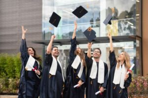 celebrating graduation with graduates throwing mortar boards up in the air as illustration of supporting companies that sponsored this project