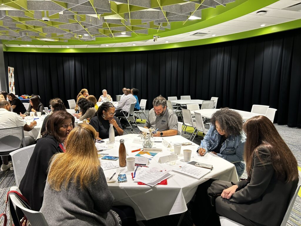 group of people around one of several round tables