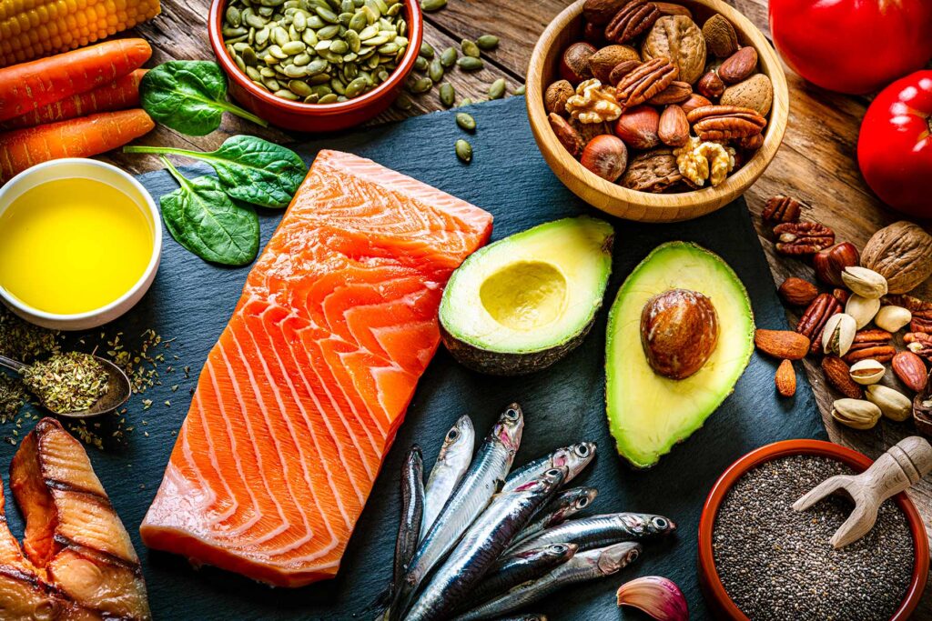 images shows an array of salmon, avocado, oil and nuts and seeds