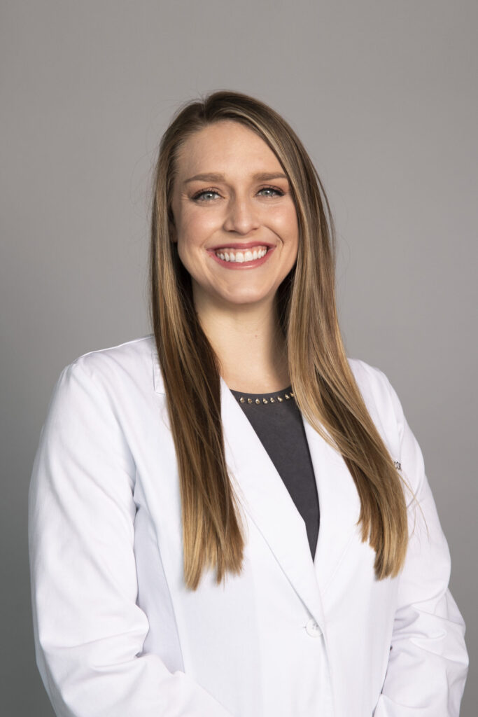 Dr. Jade Coats in white coat, talks about being an empathetic OD in this podcast