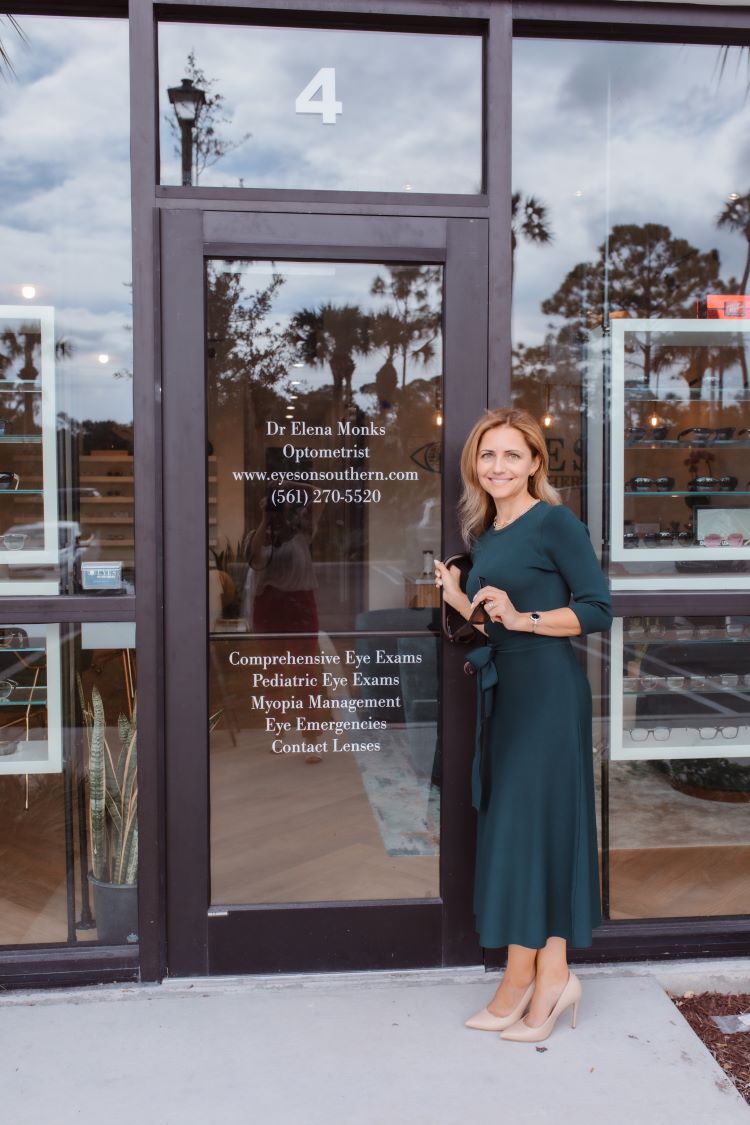 Dr. Monks outside her new office front door, wearing forest green dress