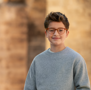 boy, around 10, in gray sweater wearing glasses
