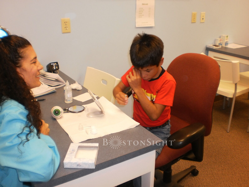 boy putting on a scleral lens by himself