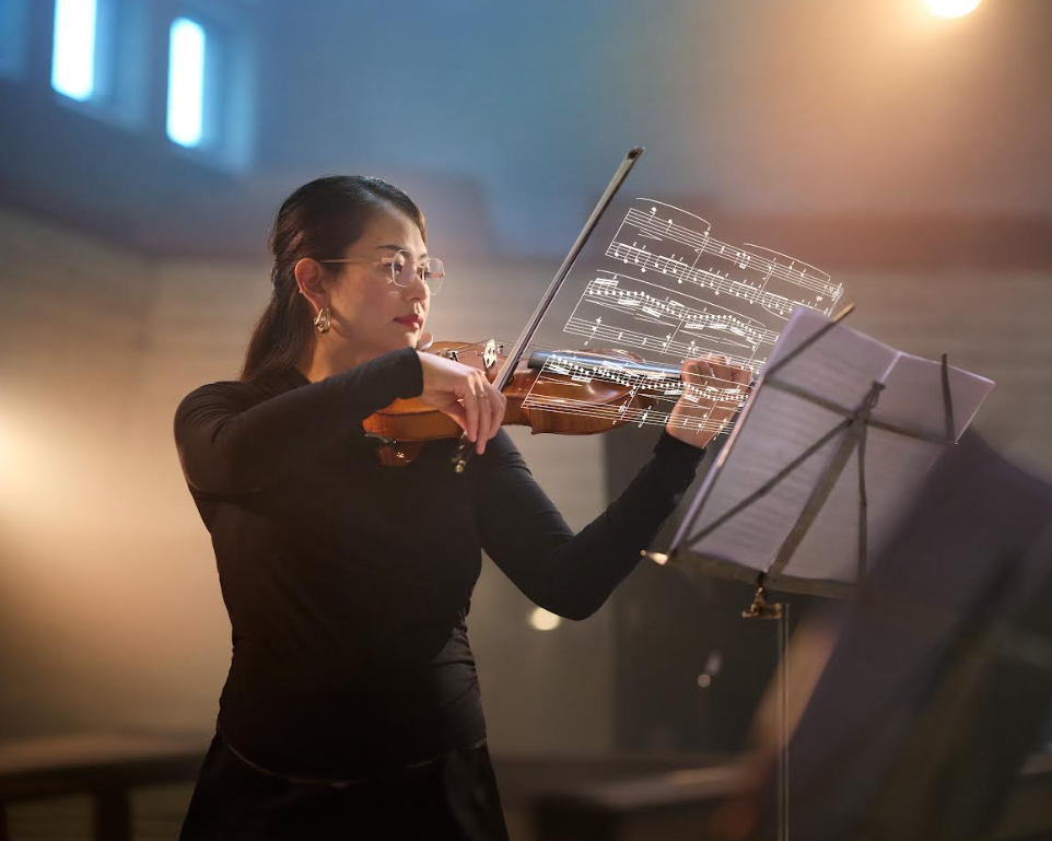 a violinist uses the new hoya technology to see her sheet music more clearly.