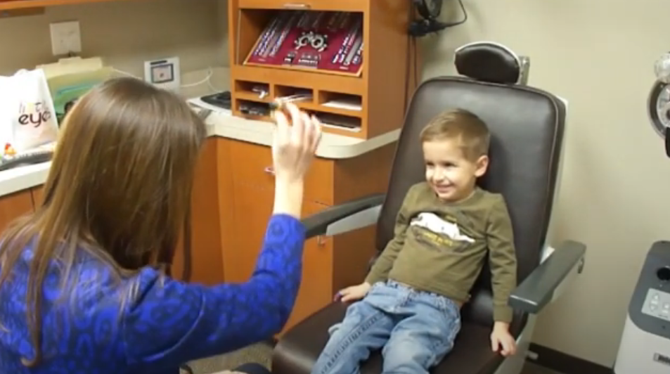 A student happily receives his eye exam.
